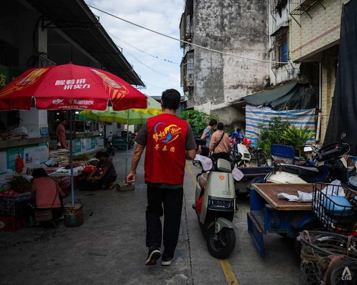  Một tình nguyện viên của Hiệp hội Tình nguyện Đoàn tụ Gia đình Hoa kiều Triều Châu. Ảnh: CNA. 