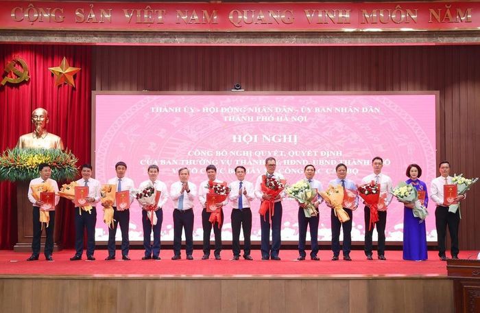 Phó Bí thư Thường trực Thành ủy Hà Nội Nguyễn Trọng Đông và Chủ tịch UBND thành phố Hà Nội Vũ Đại Thắng trao các quyết định của Ban Thường vụ Thành ủy Hà Nội cho các đồng chí. Ảnh: Văn Điệp – TTXVN