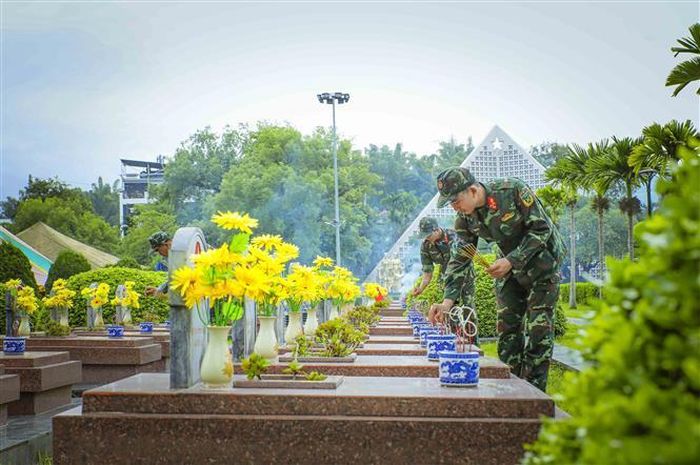 Chiến sĩ Bộ Chỉ huy Quân sự tỉnh Điện Biên thắp hương mộ phần các Anh hùng, liệt sĩ tại Nghĩa trang Liệt sĩ A1 trước khi tiến hành khai quật lấy mẫu. Ảnh: Xuân Tư - TTXVN
