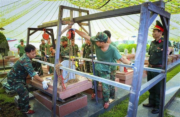Phần nắp mộ được nâng lên bằng hệ thống pa lăng xích, phục vụ quá trình khai quật và lấy mẫu. Ảnh: Xuân Tư - TTXVN