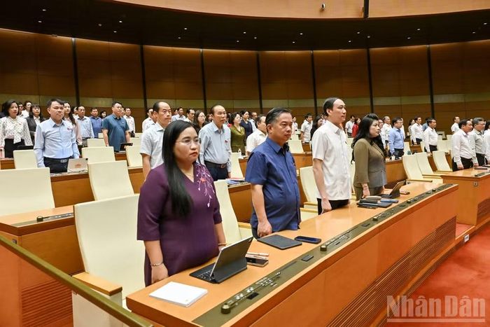 Trong không khí trang nghiêm, các đại biểu Quốc hội dành một phút mặc niệm tưởng nhớ cố Chủ tịch Quốc hội Lào Saysomphone Phomvihane. (Ảnh: THỦY NGUYÊN)