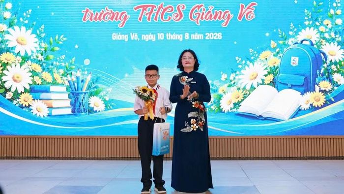 Nhà giáo Tô Thị Hải Yến, Hiệu trưởng Trường trung học cơ sở Giảng Võ tặng quà cho học sinh. (Ảnh: THANH TÙNG)