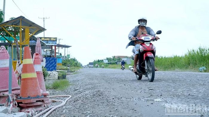 Công trình thi công nham nhở với cọc tiêu cảnh báo sơ sài, người dân phải lách qua khu vực đá lầy lội để đi lại. (Ảnh: Hữu Tùng)