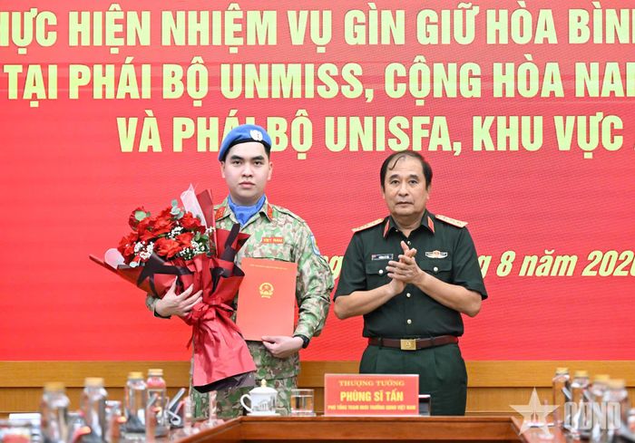 Thượng tướng Phùng Sĩ Tấn trao Quyết định của Chủ tịch nước cho Đại úy Nguyễn Ngọc Anh. 