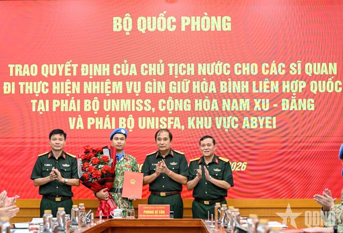 Thượng tướng Phùng Sĩ Tấn và đại diện chỉ huy Binh chủng Hóa học chúc mừng Đại úy Nguyễn Văn Nam được trao Quyết định của Chủ tịch nước.
