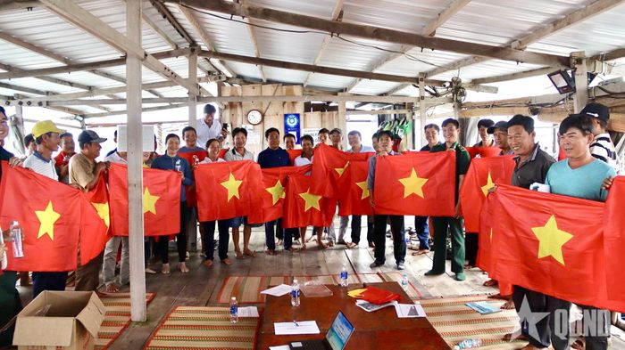 Đồn Biên phòng Long Sơn trao cờ Tổ quốc tặng các hộ nuôi trồng thủy sản. 