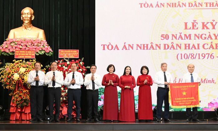  Phó Chủ tịch UBND TPHCM Trần Văn Bảy trao Cờ truyền thống cho lãnh đạo TAND TPHCM. Ảnh: VIỆT DŨNG 