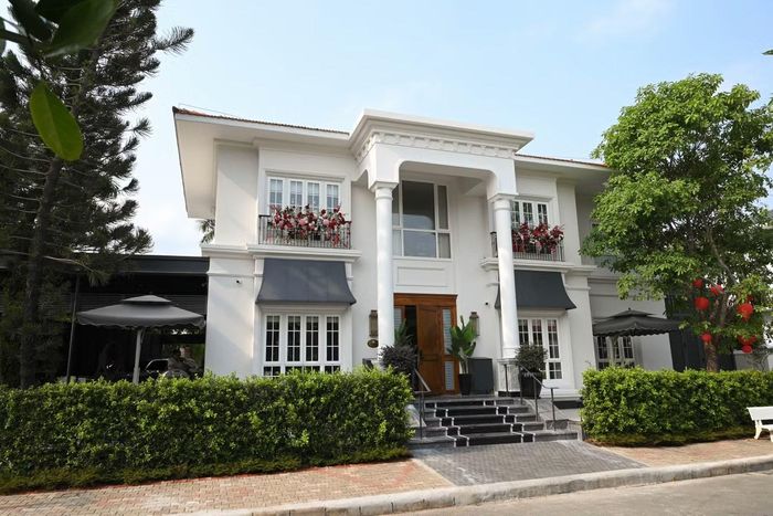  Chia sẻ với Tiền Phong, Thu Hương cho biết căn biệt thự được gia đình sử dụng từ năm 2017. Ngôi nhà nằm trong khu biệt thự Phú Gia, có một mặt hướng về hồ sinh thái và mặt còn lại nhìn ra đại lộ Nguyễn Văn Linh. Mặt tiền gây chú ý với gam trắng chủ đạo, hệ cột lớn, các đường phào chỉ và mái hiên mang phong cách tân cổ điển. Ảnh: NVCC. 