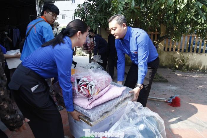  Đoàn viên, thanh niên hỗ trợ người dân thôn Bái Giang cũ di chuyển đến nơi ở tạm cư. ﻿Ảnh: Nguyễn Thắng 