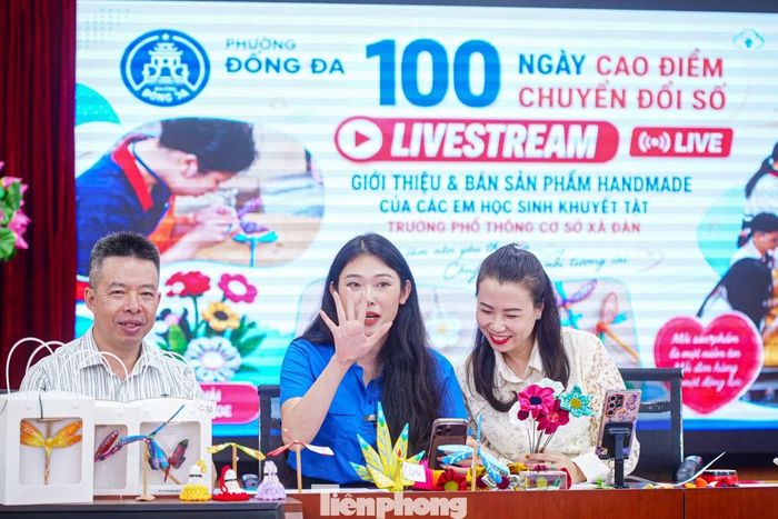  Chị Nguyễn Mai Anh - Bí thư Đoàn phường Đống Đa, người dẫn phiên livestream (ở giữa), cho biết, hoạt động nhằm đưa chuyển đổi số đến gần người dân từ những câu chuyện đời thường, giúp sản phẩm và những giá trị tốt đẹp của cộng đồng được lan tỏa trên môi trường số. Việc lựa chọn sản phẩm của học sinh khuyết tật Trường PTCS Xã Đàn mở đầu chuỗi livestream cũng gửi gắm thông điệp chuyển đổi số lấy người dân làm trung tâm, không để ai đứng ngoài những cơ hội công nghệ mang lại. 