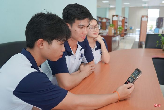 Em Chanthavong Chonat (người cầm điện thoại) cùng các bạn học thường xuyên xem các trang báo ở quê hương để cập nhật thông tin về Quốc tang.