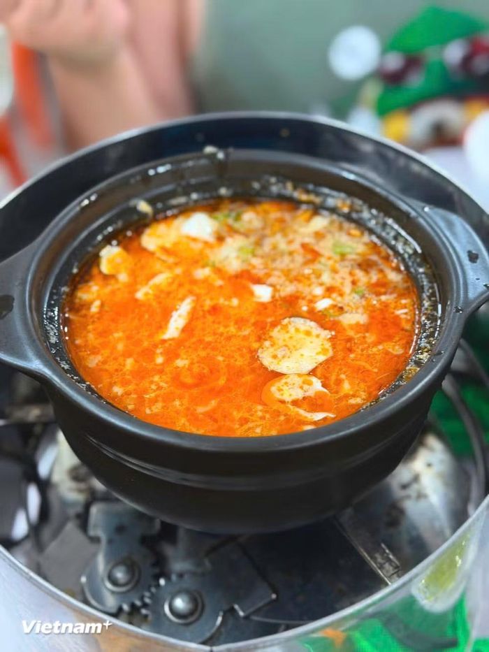 Nước lẩu thường được nấu từ xương hầm kết hợp với riêu tôm, cà chua và một số gia vị truyền thống để tạo nên vị chua thanh, đậm đà nhưng không gắt. (Nguồn: Vietnam+)