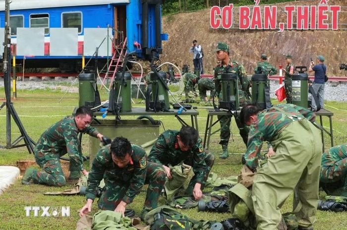 Lực lượng hóa học thu dọn quân trang sau khi thực hiện bài thi tẩy trùng hiện trường bị nhiễm chất độc hại. (Ảnh: Trọng Đức/TTXVN)
