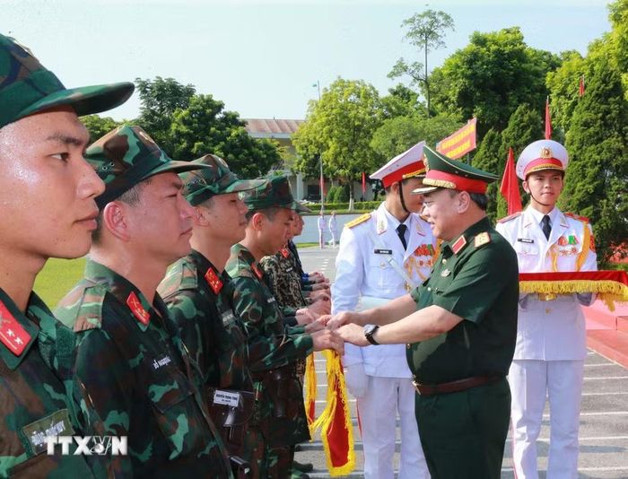 Trung tướng Lê Quang Đạo, Phó Tổng Tham mưu Quân đội Nhân dân Việt Nam tặng cờ lưu niệm cho các đơn vị tham gia hội thao. (Ảnh: Trọng Đức/TTXVN)