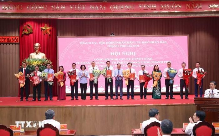 Chủ tịch Hội đồng Nhân dân thành phố Hà Nội Phùng Thị Hồng Hà và Phó Bí thư Thành ủy Hà Nội Nguyễn Văn Phong trao các quyết định của Ban Thường vụ Thành ủy Hà Nội cho các đồng chí. (Ảnh: Văn Điệp/TTXVN)