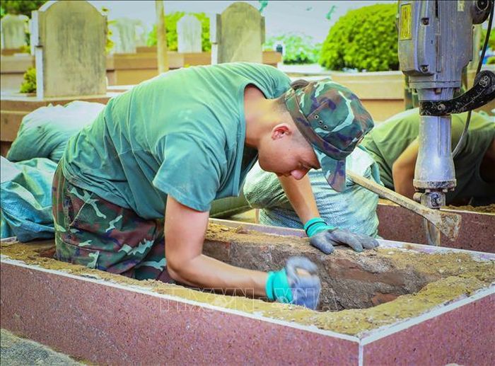Chiến sĩ cẩn trọng khi thực hiện công việc khai quật mộ liệt sĩ. Ảnh: Xuân Tư/TTXVN