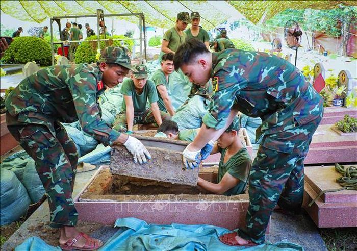 Các chiến sĩ khai quật phần mộ liệt sĩ phục vụ công tác lấy mẫu ADN. Ảnh: Xuân Tư/TTXVN