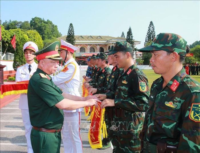 Thượng tướng Nguyễn Quang Ngọc, Ủy viên Trung ương Đảng, Thứ trưởng Bộ Quốc phòng tặng cờ lưu niệm cho các đơn vị tại lễ khai mạc. Ảnh: Trọng Đức/TTXVN