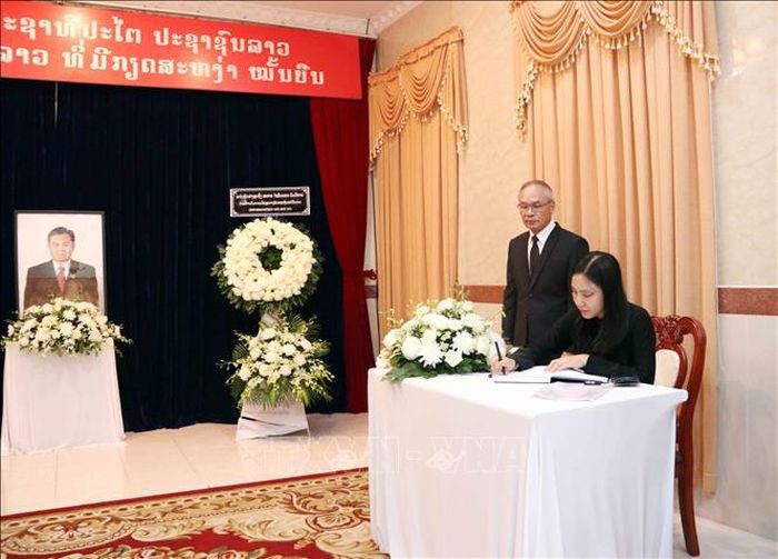 Bà Hà Thanh, Chủ tịch Liên hiệp các tổ chức hữu nghị Thành phối Hồ Chí Minh dẫn đầu đoàn đại biểu Liên hiệp các tổ chức hữu nghị Thành phố viếng và ghi sổ tang đồng chí Xaysomphone Phonvihane. Ảnh: Xuân Khu/TTXVN