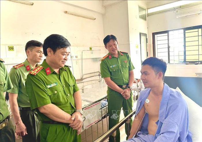 Đại tá Lê Đức Bảy, Phó Giám đốc Công an thành phố Cần Thơ thăm hỏi, động viên Thượng úy Trần Ngọc Lợi đang điều trị tại Bệnh viện Đa khoa Trung ương Cần Thơ. Ảnh: TTXVN phát