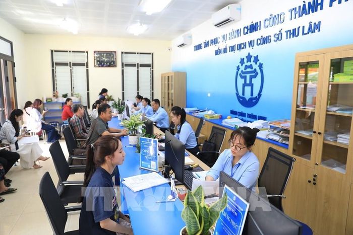 Cán bộ Điểm hỗ trợ dịch vụ công số Thư Lâm tiếp nhận, giải quyết thủ tục hành chính cho người dân. Ảnh: Trung Nguyên - TTXVN
