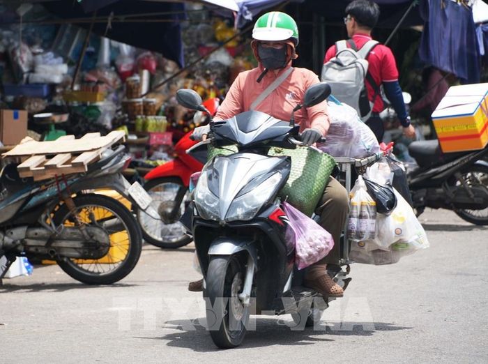 Vất vả vận chuyển hàng hóa trên đường Chương Dương - chợ Đông Ba, thành phố Huế dưới trời nắng nóng. Ảnh: Nguyên Lý - TTXVN