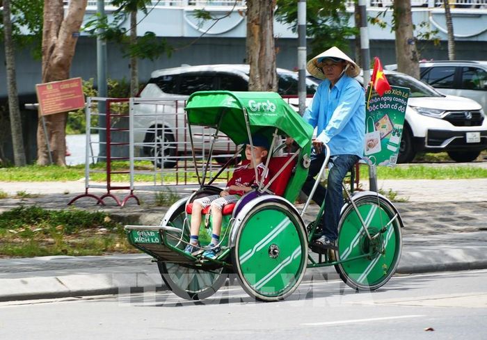 Người đạp xích lô trên đường Lê Duẩn, thành phố Huế đội nón rộng vành để giảm tác động nắng nóng. Ảnh: Nguyên Lý - TTXVN