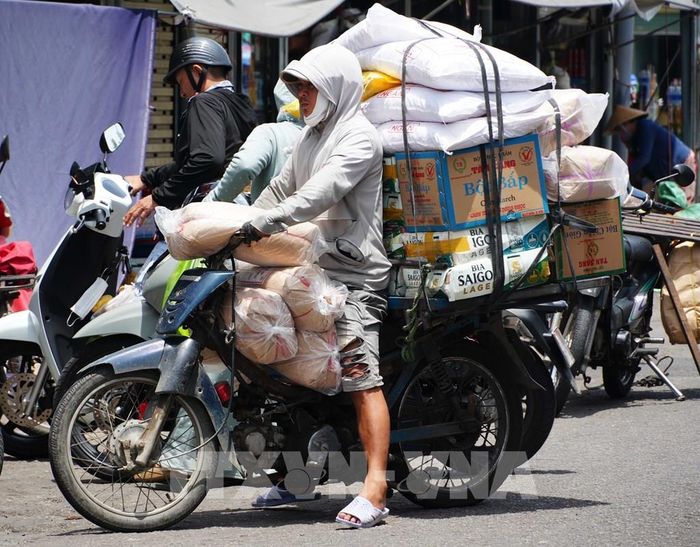 Vất vả vận chuyển hàng hóa trên đường Chương Dương - chợ Đông Ba, thành phố Huế, dưới trời nắng nóng. Ảnh: Nguyên Lý - TTXVN