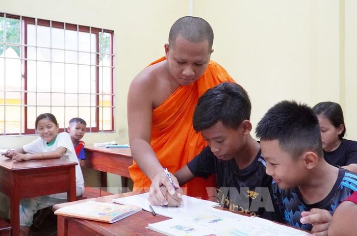 Hướng dẫn học sinh viết chữ Khmer. Ảnh: Văn Sĩ - TTXVN 