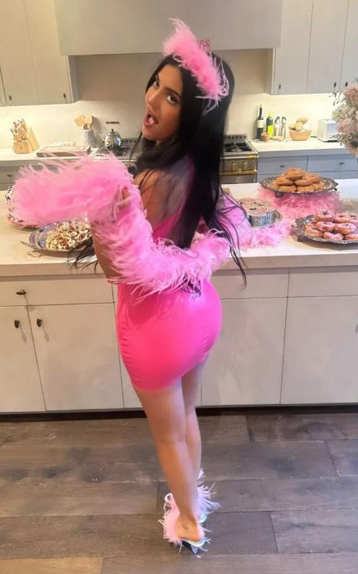 Kylie Jenner tạo dáng bên bàn tráng miệng trong bộ trang phục màu hồng nổi bật.  Ảnh: IGNV