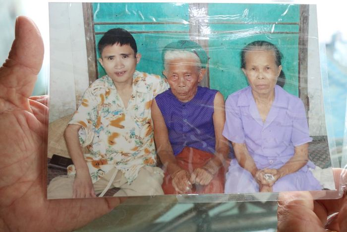 Anh Phạm Đức Anh (bìa trái) - người con trai út của vợ chồng bà Năm, đã sống 32 năm với những di chứng nặng nề của chất độc da cam.