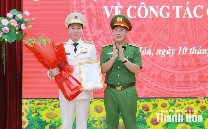 Thứ trưởng Bộ Công an Nguyễn Văn Long trao quyết định của Bộ trưởng Bộ Công an và tặng hoa chúc mừng Giám đốc Công an tỉnh Thanh Hóa Hoàng Quốc Việt.