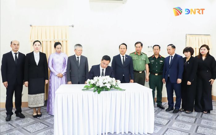 Bí thư Thành ủy Lê Ngọc Quang viết vào sổ tang đồng chí Xaysomphone Phomvihane. Ảnh: NGỌC PHÚ
