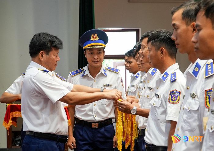 Thiếu tướng Trần Quang Tuấn, Tư lệnh Vùng Cảnh sát biển 2 trao cờ lưu niệm cho các đơn vị tham gia hội thi, hội thao. Ảnh: HỒ QUÂN