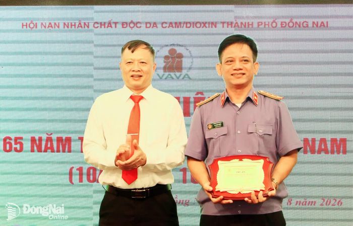 Phó Chủ tịch Ủy ban MTTQ Việt Nam thành phố Nguyễn Tấn Phú thay mặt Hội Nạn nhân chất độc da cam/dioxin thành phố Đồng Nai tặng biểu trưng tri ân tổ chức có đóng góp tích cực đối với hoạt động hội. Ảnh: Văn Truyên