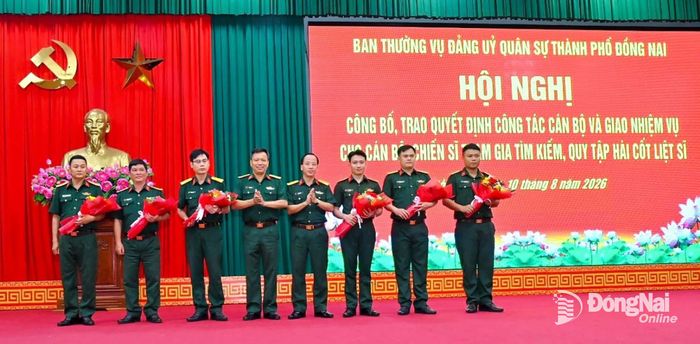 Đại tá Vũ Mạnh Hùng (thứ 4 từ trái qua), Phó Chỉ huy trưởng Bộ Chỉ huy Quân sự thành phố và Đại tá Bùi Khánh Hòa (thứ 4 từ phải qua), Phó Chỉ huy trưởng Bộ Chỉ huy Quân sự thành phố trao quyết định tăng cường lực lượng tìm kiếm, quy tập hài cốt liệt sĩ. Ảnh: Văn Chung