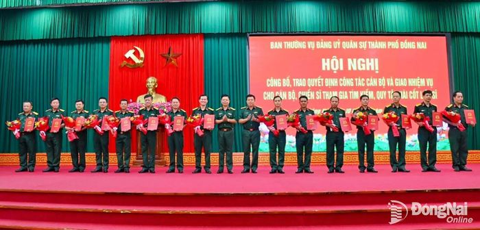 Đại tá Nguyễn Thanh Phong, Thành ủy viên, Phó Bí thư Thường trực Đảng ủy Quân sự, Chính ủy Bộ Chỉ huy Quân sự thành phố (giữa) và Đại tá Phạm Minh Trí, Phó Chỉ huy trưởng Bộ Chỉ huy Quân sự thành phố (thứ 8 từ phải qua) trao quyết định công tác cán bộ. Ảnh: Văn Chung