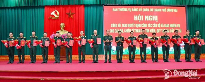 Đại tá Võ Thành Danh, Ủy viên Ban Thường vụ Thành ủy, Phó Bí thư Đảng ủy Quân sự, Chỉ huy trưởng Bộ Chỉ huy Quân sự thành phố (giữa) và Đại tá Bùi Văn Sỹ, Ủy viên Thường vụ Đảng ủy, Phó Chính ủy Bộ Chỉ huy Quân sự thành phố (thứ 8 từ phải qua) trao quyết định cán bộ. Ảnh: Văn Chung