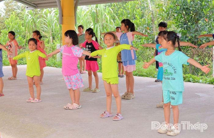 Học sinh được giáo viên hướng dẫn khởi động đúng kỹ thuật trước khi xuống nước tập bơi.