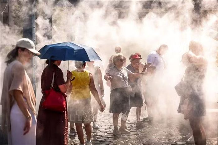 Người dân tránh nóng dưới hệ thống phun sương tại Budapest, Hungary. Ảnh: THX/TTXVN phát