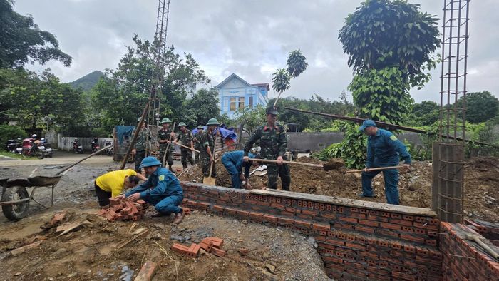 Cán bộ, chiến sĩ Bộ Chỉ huy Quân sự tỉnh và dân quân phường Đoàn Kết giúp gia đình bà Phạm Thị Cúc (ở tổ 7, phường Đoàn Kết, là thân nhân người có công với cách mạng) xây dựng nhà.