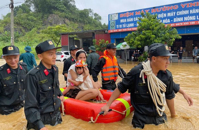 Lực lượng chức năng hỗ trợ người dân phường Lào Cai di chuyển đến nơi an toàn. Ảnh Phạm Bằng