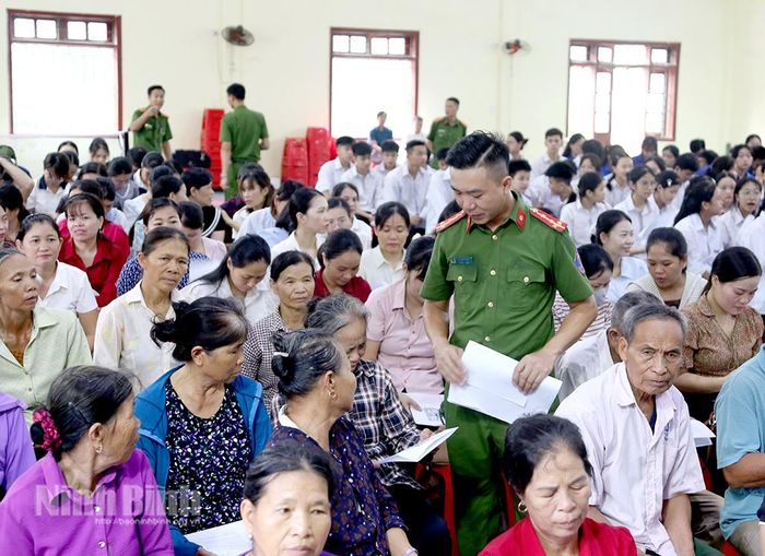 Công an xã hướng dẫn cài đặt phần mềm ôn luyện lý thuyết sát hạch. Ảnh: Minh Đường
