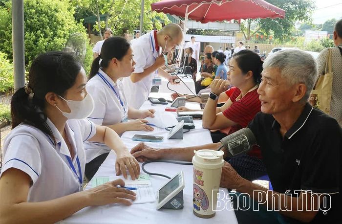 Cán bộ y tế khám sức khoẻ cho người dân.