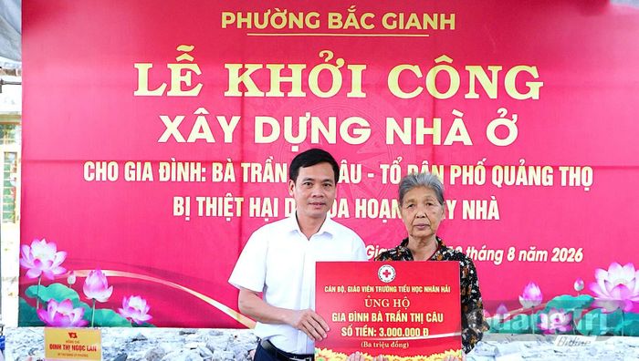 Đại diện cán bộ, giáo viên Trường tiểu học Nhân Hải trao biển hỗ trợ cho gia đình bà Trần Thị Câu - Ảnh: N.M