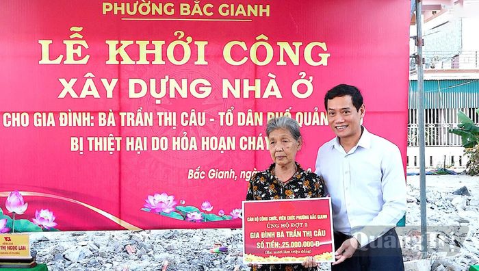 Đại diện cán bộ, công chức, viên chức phường Bắc Gianh trao biển hỗ trợ gia đình bà Trần Thị Câu - Ảnh: N.M