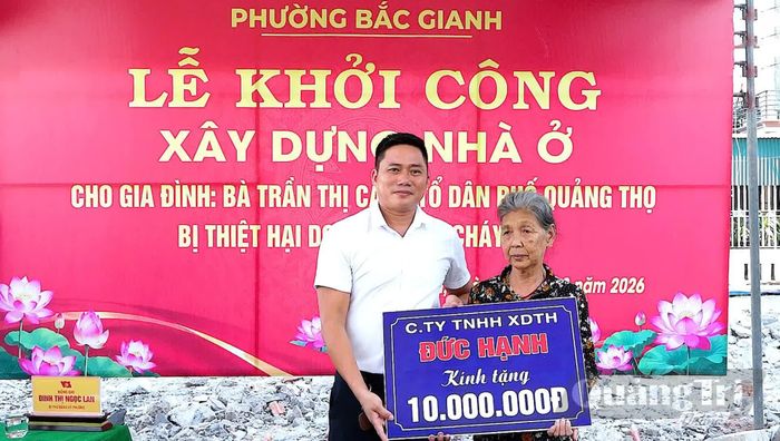 Đại diện Công ty TNHH tổng hợp Đức Hạnh trao biển hỗ trợ gia đình bà Trần Thị Câu - Ảnh: N.M