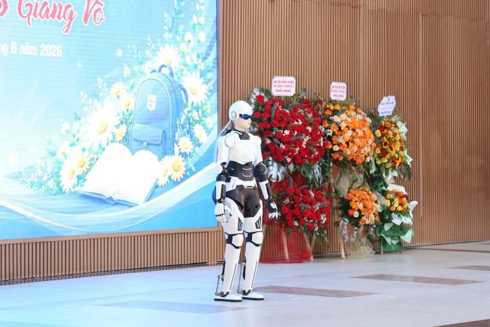 Các em thích thú giao lưu với robot AI hình người AIMOGA. Ảnh: T.Nga