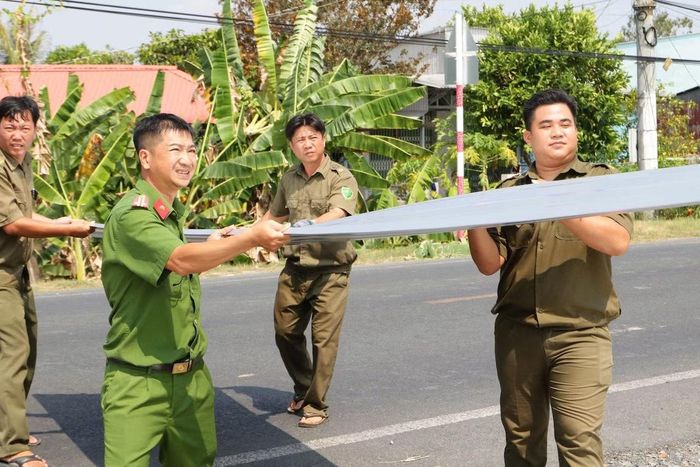 Lực lượng tham gia bảo vệ ANTT ở cơ sở hỗ trợ người dân khắc phục sự cố do dông lốc.