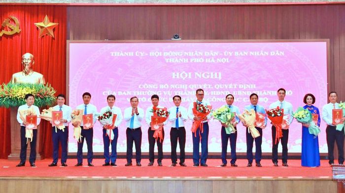 Phó Bí thư Thường trực Thành ủy Hà Nội Nguyễn Trọng Đông; Phó Bí thư Thành ủy, Chủ tịch UBND thành phố Hà Nội Vũ Đại Thắng trao quyết định của Ban Thường vụ Thành ủy Hà Nội cho ông Nguyễn Thanh Liêm và ông Vũ Minh Tuấn cùng các quyết định về công tác cán bộ nhận nhiệm vụ mới. Ảnh: Báo Hanoimoi